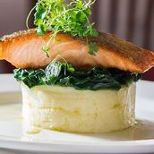 Grilled Salmon steak with mashed potato and spinach saute